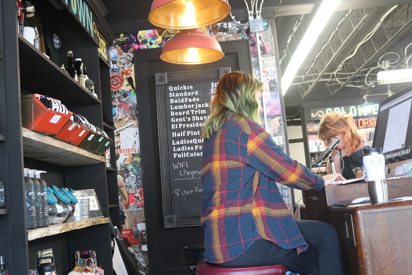 Shelves of pomades and hair products beside the counter, with a menu board above.